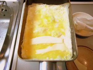 卵液１回目、端にちぎったチーズを並べる