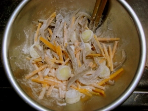 細切りにしたエンペラ、ニンジン、長ネギをボールに入れ、小麦粉をまぶす