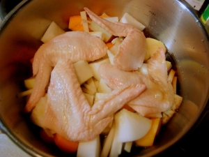 圧力鍋に根菜、鶏手羽先、醤油、砂糖、みりん、酒、酢、水を入れる