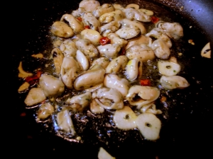 オリーブオイルでニンニクと唐辛子を炒めたらムール貝を入れる