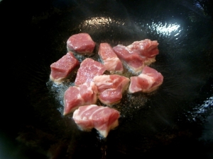 強火で豚肉を炒める