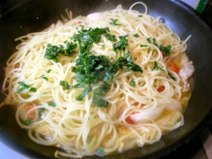 茹で上がったパスタ、パスタの茹で汁、バジルを加える