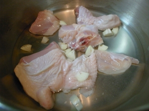 圧力鍋に骨付き鶏肉、ニンニク、水を入れて加熱 15分