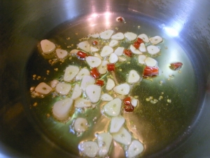 圧力鍋にオリーブオイル、ニンニク、唐辛子、じっくり炒める