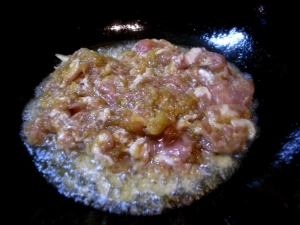中華鍋を熱して、すりおろしタマネギごと豚肉を炒める