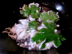ゴーヤの葉の片面に天ぷら粉をつけて揚げる