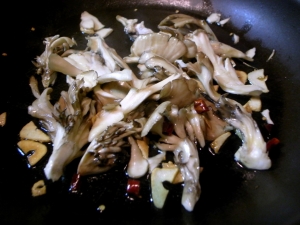 オリーブオイルでニンニク、唐辛子、舞茸をじっくり炒める