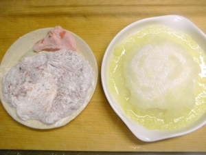 豚肉は包丁の背で叩いて小麦粉をまぶす、タマネギとニンニクをすりおろす