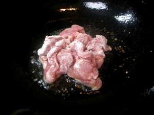 塩胡椒した豚肉に小麦粉をまぶして炒めていく