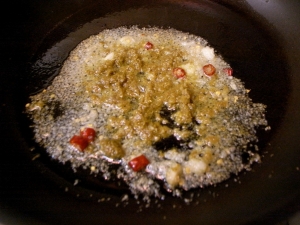 フライパンにサラダオイルを熱し、ニンニク、生姜、唐辛子、グリーンカレーペーストを炒める
