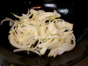 中華鍋をきれいにしてから、ニンニク、生姜、タマネギを炒める