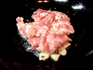 中華鍋に油を熱し、ニンニク、唐辛子、豚肉