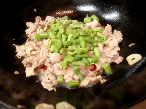 豚肉の色が変わったらインゲンを入れる