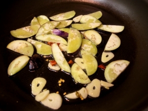 オリーブオイル、ニンニク、唐辛子、茄子を炒める