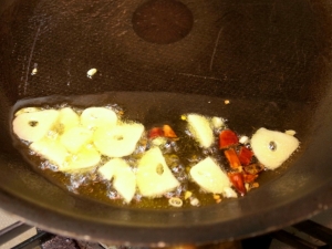 オリーブオイルにニンニク、唐辛子を弱火で加熱する