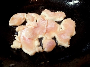 片栗粉をまぶした鶏胸肉を炒める