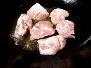 小麦粉をまぶした豚ヒレ肉を炒める