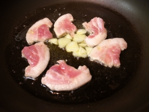 オリーブオイル、豚バラ肉、ニンニクを炒める