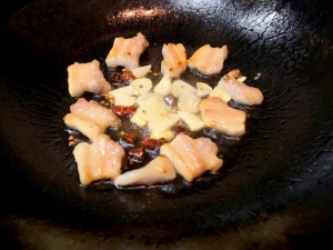 塩豚、ニンニク、唐辛子をじっくり炒める