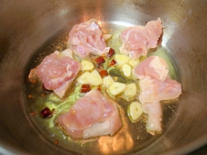 圧力鍋にオリーブオイル、ニンニク、唐辛子、鶏もも肉