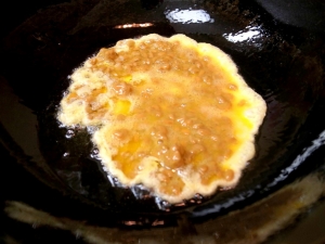 サラダ油とごま油を熱して、納豆と卵を入れる