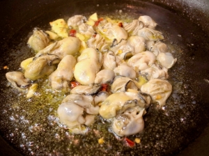 オリーブオイル、ニンニク、唐辛子、牡蠣を炒める