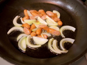 オリーブオイルでソーセージと玉ねぎを炒める