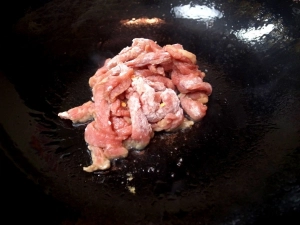 片栗粉をまぶした牛肉を炒める