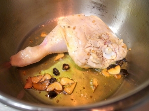 圧力鍋にオリーブオイル、にんにく、唐辛子で鶏肉の表面を焼く
