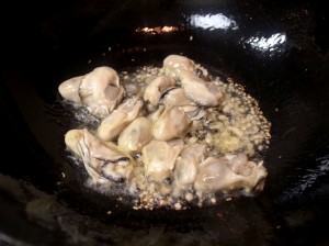 ごま油に生姜を熱して牡蠣を入れる