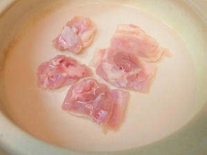 土鍋に水を張って鶏肉を茹でる