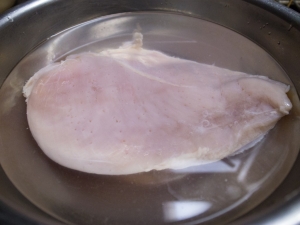 ホークで穴を開けた鶏胸肉を水に２０分間ほど漬ける