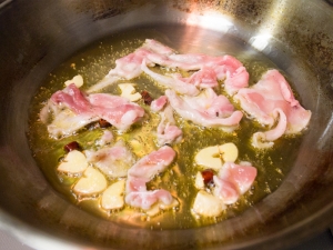 オリーブオイル、ニンニク、唐辛子、豚肉を炒める