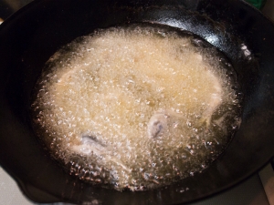 小麦粉をはたいたアジを低温で揚げていく