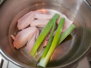 圧力鍋に鶏手羽先、長ネギ、水