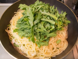 茹で上がったパスタと春菊の葉を加える