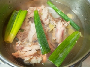 圧録鍋に鶏ガラ、生姜、ねぎの葉の部分を入れて圧力をかける