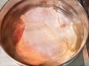シャトルシェフの調理鍋に米、水を入れ、上に鶏もも肉をのせる