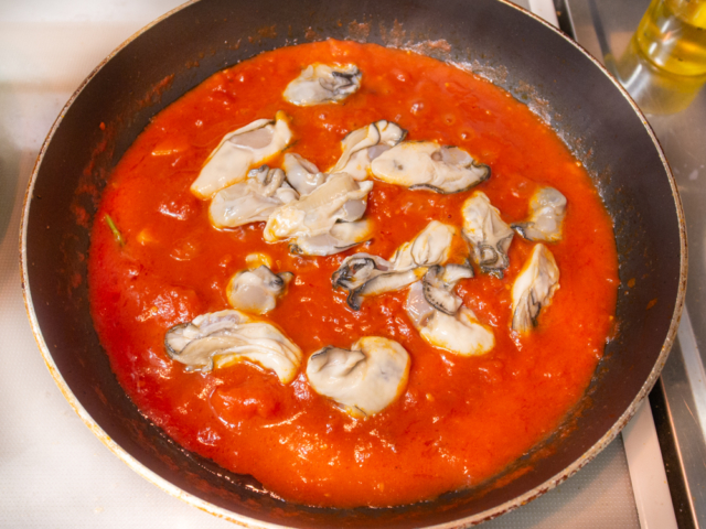 トマトをへらで潰して５分ほど煮詰めたら牡蠣を加える
