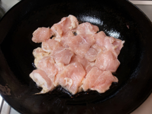 片栗粉をまぶした鶏胸肉を炒める