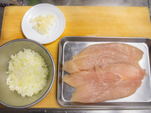 鶏胸肉は半分に切り、タマネギとニンニクはみじん切りにする