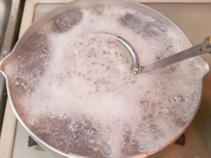 アクを取りながらアサリを茹でる