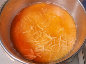 圧力鍋にご飯、アサリとタコの茹で汁、生姜を入れて火をつける