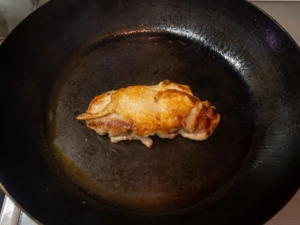 皮目に焼き色がついたらひっくり返してふたをして火を通す