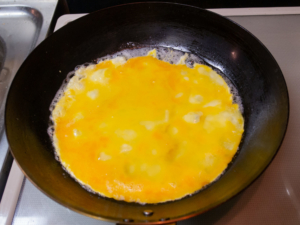 フライパンにバターを熱して溶いた卵を入れる