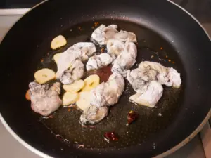 小麦粉をまぶした牡蠣を炒める