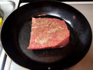 サラダ油をひいたフライパンで牛肉の表面を焼く