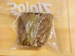 ジップロックに牛肉、ローリエを入れて空気を抜く