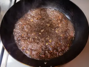 肉汁、ワイン、醤油、タマネギ、ニンニクを煮詰めてソースにする