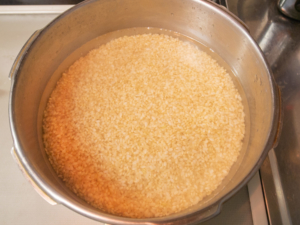 圧力鍋に玄米と水を入れる